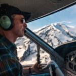 Pilot navigates De Havilland Otter with Mt Redoubt volcano in the background