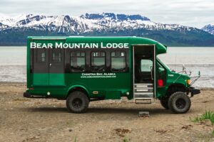 Bear Mountain lodge shuttle bus parked on the remote beach of Chinitna Bay